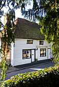 White clapboard house with black paintwork and lettering in Egerton, Kent, England, UK