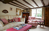 Co-ordinating check fabric upholstery in timber framed living room of Egerton cottage, Kent, England, UK