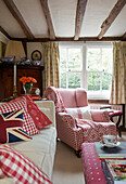 Co-ordinating checked fabric upholstery in timber framed living room of Egerton cottage, Kent, England, UK