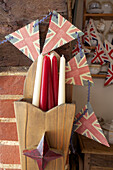 Red and white candles with Union Jack bunting in Egerton cottage, Kent, England, UK