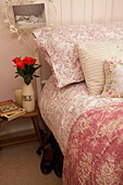 Floral quilt and pillows on bed in Egerton cottage, Kent, England, UK