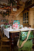 Fleckige grüne Tasche am Esstisch mit Spitzentuch in einem Haus in Tenterden, Kent, England, UK