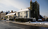 Bemalte Hausfassade mit efeubewachsenem Turm und Schneefall in Tenterden, Kent, England, Vereinigtes Königreich