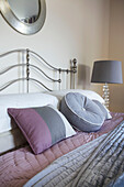 Pink and grey cushions on bed in modern home Bath Somerset, England, UK