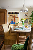 Dining room with wicker chairs and metallic lampshade in Smarden home Kent England UK