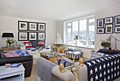 Photographic prints in nautical styled living room with uncurtained window, Dartmouth, Devon, UK