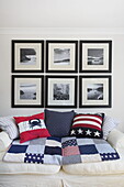 Black and white photographic prints above sofa with American style furnishings in Dartmouth home, Devon, UK