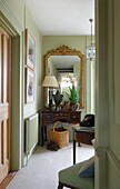 Light green hallway with gilt-framed mirror in hallway of Etchingham farmhouse East Sussex England UK