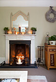 Kerzen im Kamin eines Wohnzimmers in Staplehurst, Kent, England, UK