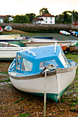 Blue boat moored on Emsworth beach Hampshire England UK