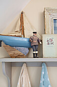 Spielzeugboot und männliche Figur auf einem Badezimmerregal in Kent, England