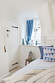 Blue curtain with tieback in window of Dorset cottage bedroom Corfe Castle England UK