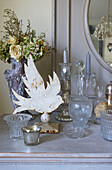 Vintage glassware with dried flowers and bird ornament on side cabinet in Victorian villa Kent England UK