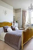 Senffarbenes Samtdoppelbett mit brauner Steppdecke in viktorianischer Villa in Kent, England UK