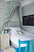 Single bed with canopy and chalkboard in girls room Bishops Sutton family home Alresford Hampshire England UK