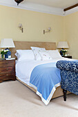 Light blue blanket on double bed with upholstered chaise longue in Bishops Sutton home Alresford Hampshire England UK