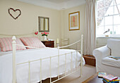 Heart shaped floral wreath above white double bed with armchair in Bishops Sutton Alresford Hampshire England UK
