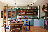 Küchentisch und -stühle mit offenem Regal in einem Haus in Hackney, London, England, UK