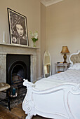 Weißes Doppelbett mit originalem Kamin in einem Haus in Hackney London England UK