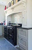 Black range oven in recessed original fireplace of Woodchurch kitchen Kent England UK