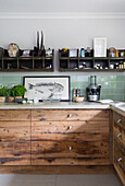 Vintage shelves above worktop with salvaged wooden drawers in Rye kitchen East Sussex UK