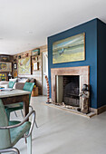Artwork on teal feature wall with painted floorboards in Rye home East Sussex UK