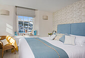 Light blue blanket with cane chair and view of Dartmouth harbour from Devon bedroom UK