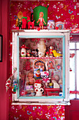 Collection of vintage toys in wall mounted display cabinet Tenterden Kent UK