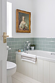 Antikes Porträt mit salbeigrünen Metrofliesen in einem Badezimmer in Southsea, England
