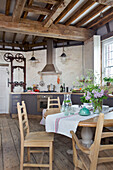 Arts and crafts table and chairs in open plan kitchen of Grade ll listed windmill conversion Kent UK
