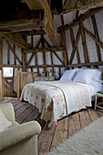 Double bed and timber beams in Grade ll listed windmill conversion Kent UK