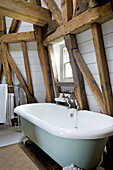 Freestanding bath below window on 'dust floor' of Grade ll listed windmill conversion Kent UK