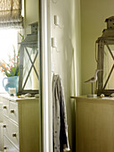 Spiegelung einer Kommode mit Sturmlaterne im Schlafzimmerspiegel in einem Haus in Kensington, London, England, UK