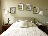 Silver framed artwork above double bed with matching lamps in Kensington home London England UK