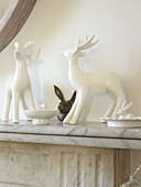 Chinaware reindeer on marble fireplace in London home England UK
