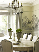 Spring bulbs on dining table with cut-glass chandelier in East Sussex country house England UK