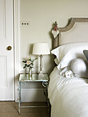 Cut roses and lamp on bedside table in East Sussex country house England UK
