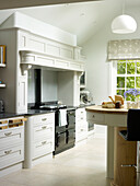 Breakfast bar with black range oven in kitchen of Nottinghamshire home England UK