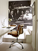 Bürostuhl aus braunem Leder am Schreibtisch mit Kunstwerk auf dem Treppenabsatz in einem Stadthaus im Norden Londons, England, UK