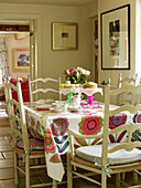 Sponge cake and tulips on dining table with floral patterned cloth Nottinghamshire home England UK