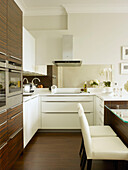 White leather armchairs with integral ovens in kitchen of Little Venice townhouse London England UK