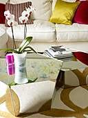 Orchid on mirrored coffee table in living room of Little Venice townhouse London England UK