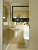 Glass shower cubicle with wall mounted bathroom cabinet in Little Venice townhouse London England UK