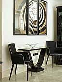 Pair of black upholstered chairs with artwork and console in London townhouse, UK