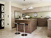 Large clock in wooden fitted kitchen of London townhouse, UK