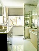 Doppelwaschbecken mit freistehender Badewanne in verspiegelter Nische in einem Londoner Stadthaus, UK