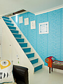 Tube station wallpaper with painted staircase in London family home, UK