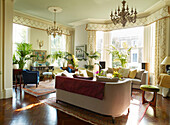 Houseplants and seating in large drawing room of London townhouse apartment, UK