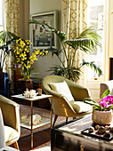 Goldener Sessel und Pflanzen mit Beistelltisch in einem Londoner Stadthaus, UK