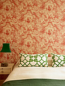 Green accent colours in bedroom with vintage wallpaper, London townhouse, UK